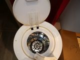 a white toilet with a white lid and a black seat