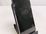 a broken cell phone sitting on a stand on a table
