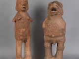 two clay figurines of a man and a woman standing next to each other
