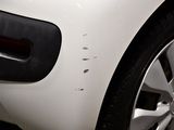 a close up of a white car with holes in the side