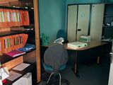 a room with a desk, a chair, and a bookcase