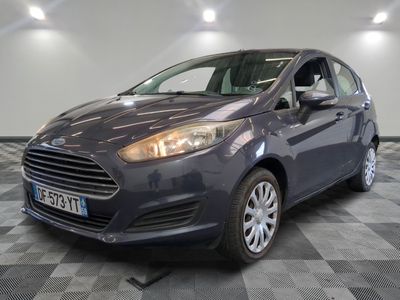 La voiture est garée dans le showroom, sur le sol à damier.