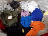 une pile de vêtements posée sur un lit