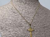 un collier avec une croix en or sur un mannequin, un mannequin, un mannequin, un mannequin, un mannequin, un mannequin, un mannequin, un mannequin, un manne