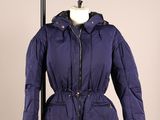La veste que porte le mannequin est bleue et possède une capuche.