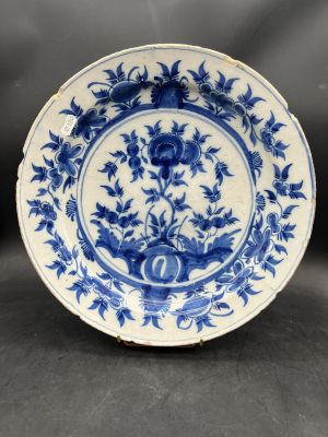 a blue and white plate with flowers and leaves on it