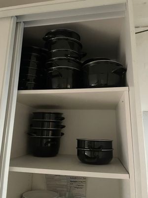de nombreuses casseroles et poêles sur les étagères de la cuisine
