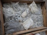 a wooden box filled with assorted items sitting on the ground