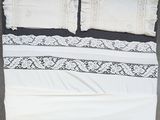 un lit blanc avec une couette et des oreillers noirs et blancs