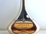 an image of a bottle of perfume sitting on top of a table