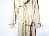 un trench-coat posé sur un mannequin, devant un fond blanc