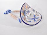 a blue and white plate with a blue ribbon on it