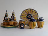 des vases en céramique jaunes et bleus et une assiette, avec une horloge en arrière-plan