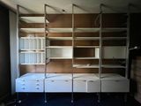 a room with a bed, shelves, and a ladder in it