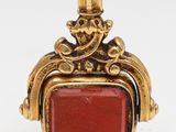 an image of a gold and red stone pendant on a white background