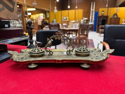 an antique brass plate with two candles on it on a red table