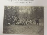 a black and white photo of a group of people with dogs