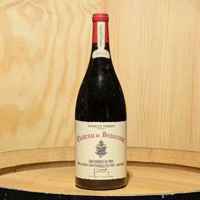 a bottle of wine sitting on top of a barrel