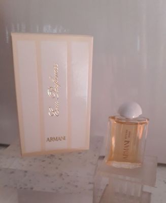 un flacon de parfum posé sur une table à côté d'une boîte