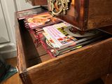 a wooden desk with a drawer full of magazines