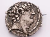 an old silver coin with a woman ' s head on top of it