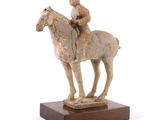 statue d'un homme à cheval sur un socle en bois