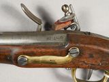 an old gun with a wooden handle on a white surface