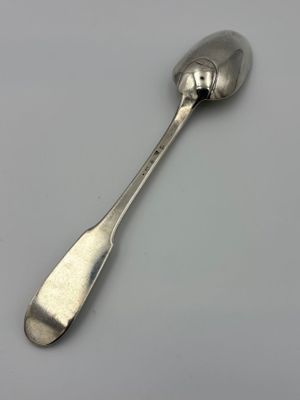 silver spoon on a white surface with a small spoon sticking out of it