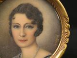 an old picture of a woman with a pearl necklace in a gold frame