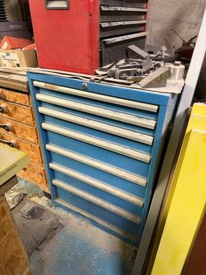 une armoire à outils bleue avec des tiroirs et une boîte rouge