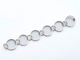 un gros plan d'un bracelet en argent orné de cinq cercles
