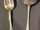two spoons and a spoon rest on a table