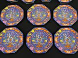 several plates with designs on them are sitting on a black surface