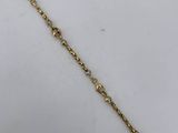 a close up of a gold chain bracelet on a white surface