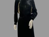 an image of a mannequin wearing a black dress with gold trim