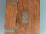 an old wooden box with a metal decoration on the front