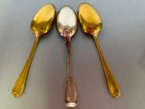 three spoons that are sitting next to each other on a table