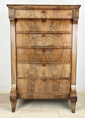 une commode en bois surmontée d'une horloge
