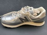 the new balance 995 is a silver and beige sneaker with a white sole