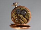 a close up of a pocket watch with a bird on top of it