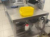 a large stainless steel table with a yellow bin on it