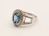 an image of a ring with a blue topaz stone surrounded by white diamonds