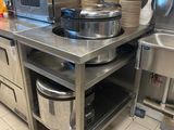 un plan de travail en acier inoxydable sur lequel sont posées une casserole et une poêle