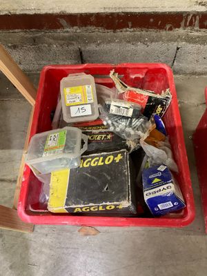 a red container filled with assorted items sitting on the floor