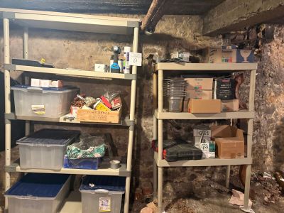 une cave sale, avec des étagères et des bacs à l'intérieur