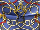 un gros plan sur une écharpe bleue et dorée ornée d'un motif