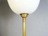 a close up of a lamp with a white glass shade on it