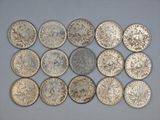 a group of silver coins sitting on top of a white surface