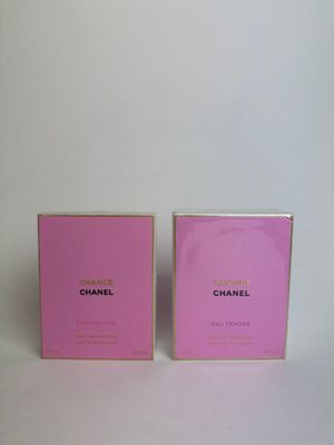 a pair of pink perfume bottles sitting on top of a white table