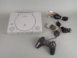a video game console with a game controller next to it